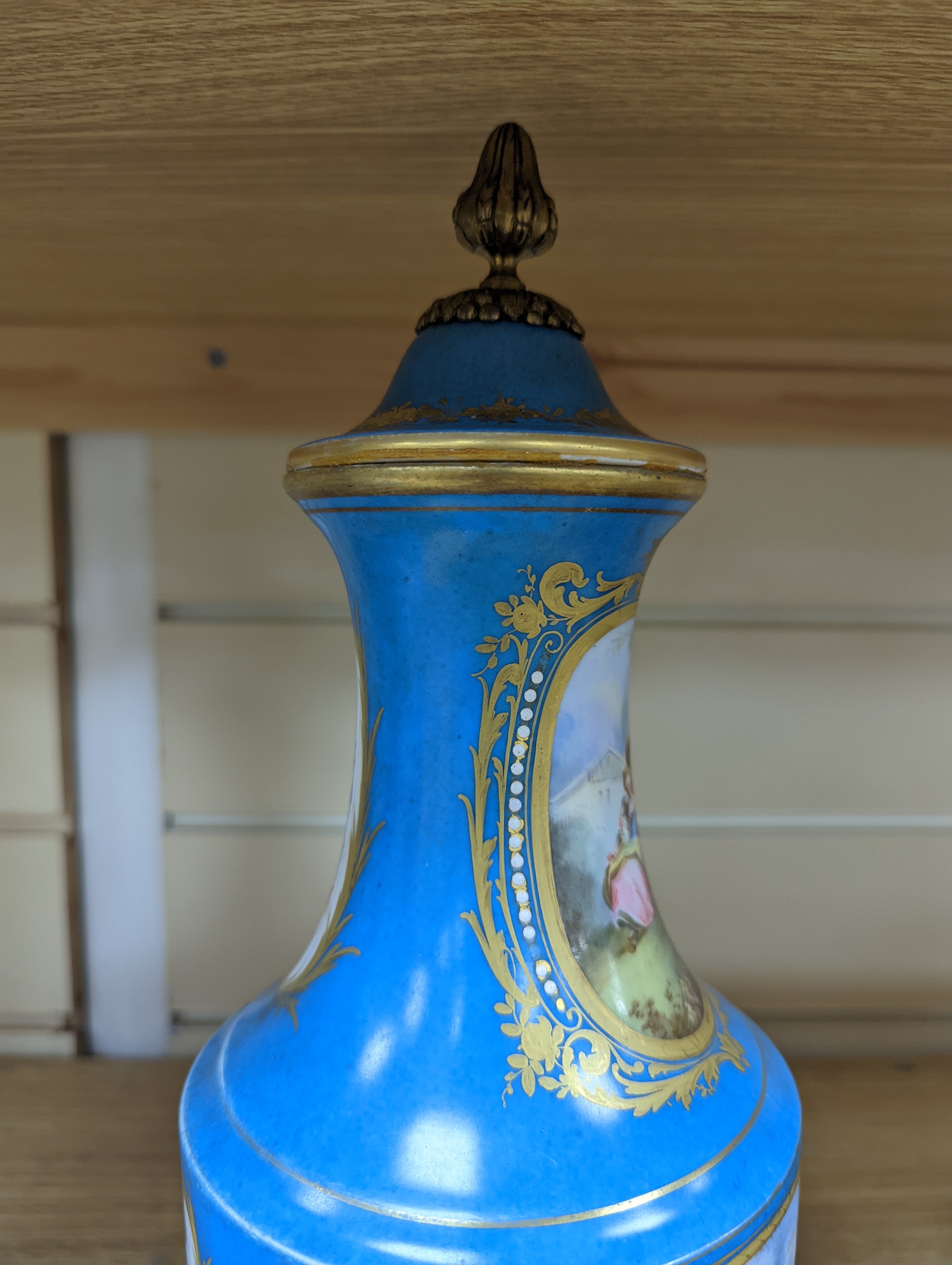 A pair of Sevres style porcelain bleu celeste ground vases and covers, 34cm